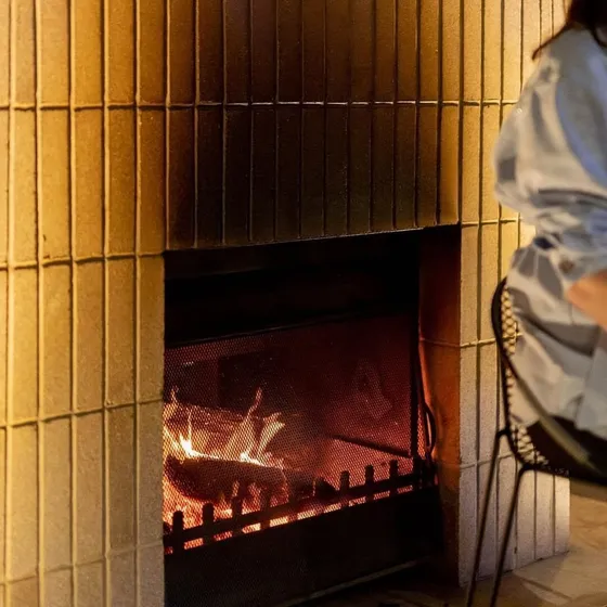 Vertical soldier-course brick fireplace with a lit fire at The Arborist rooftop bar in Geelong