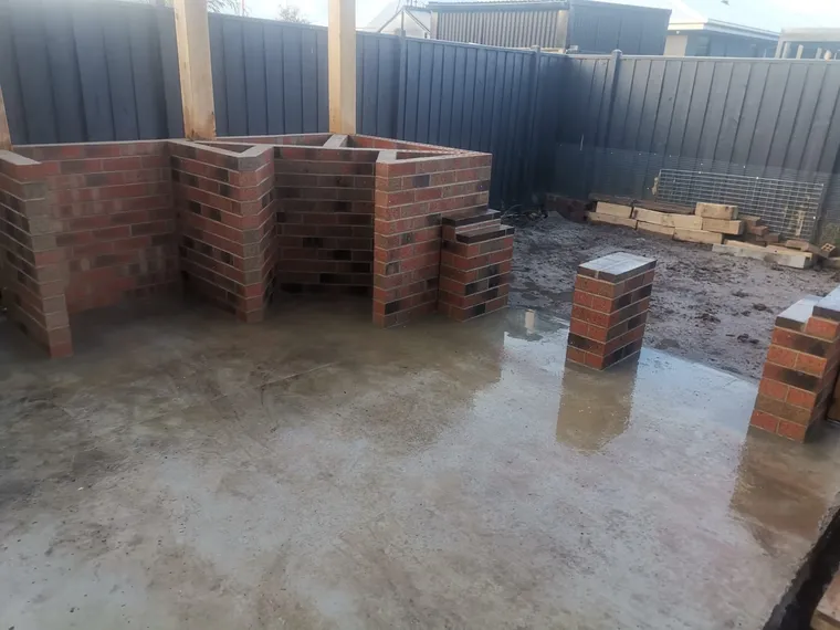 Face-brick outdoor structure and piers under construction on a new slab