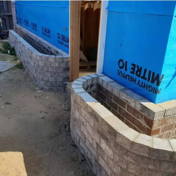 Curved radius brick garden planter walls under construction at a new build